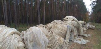 Hałda foli do przykrywania upraw porzucona w lesie